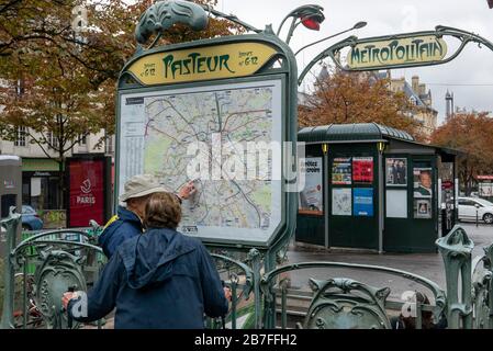 Persone che guardano una mappa fuori dall'entrata di una stazione della metropolitana a Parigi, Francia, Europa Foto Stock