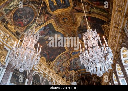 Lampadari di cristallo decorati e soffitti dipinti della Sala degli specchi al Palazzo di Versailles nella periferia di Parigi, Francia, Europa Foto Stock