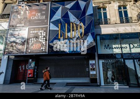 (200316) -- PARIGI, 16 marzo 2020 (Xinhua) -- I Pedoni camminano davanti al cabaret chiuso del Lido sugli Champs Elysees a Parigi, Francia, 15 marzo 2020. La Francia ha confermato un totale di 5,423 casi di infezione da coronavirus, con un aumento di 923 rispetto al giorno precedente, il più alto conteggio giornaliero da quando il virus è stato rilevato nel paese all'inizio di quest'anno, le autorità sanitarie hanno detto Domenica. Il governo ha messo un blocco parziale sul paese il sabato. Tutti i luoghi pubblici non essenziali, in particolare caffè, negozi, ristoranti e discoteche, sono chiusi fino a nuovo avviso. Solo alimentari, farmacie, stazioni di servizio a Foto Stock