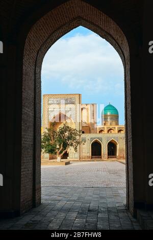 Vista sul cortile interno del complesso religioso islamico po-i-Kalyan situato intorno al minareto Kalan con la madrasa dall'arco. Bukhara. Uzbeki Foto Stock