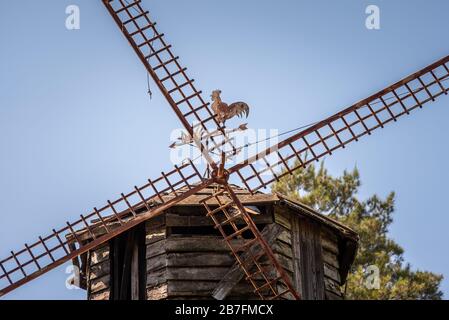 Primo piano di un vecchio mulino tradizionale olandese in legno arrugginito e grugnoso con una paletta a forma di gallo Foto Stock