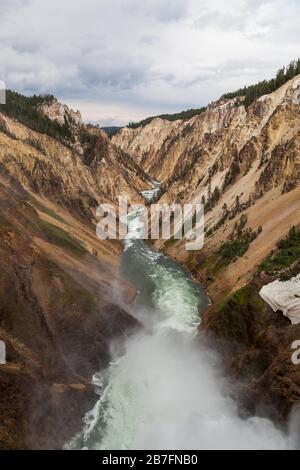 Guardando lungo il fiume Yellowstone dalla cima delle Lower Falls, mentre la nebbia sale e le rapide tagliano un percorso attraverso il Grand Canyon del Yellowstone AT Foto Stock