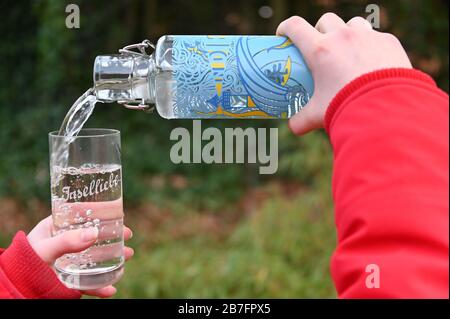 11 marzo 2020, Schleswig-Holstein, Westerland/Sylt: ILLUSTRAZIONE - acqua di rubinetto da una 'bottiglia di stilo' disponibile presso l'ufficio informazioni turistiche è riempita in un vetro con l'iscrizione 'Inselliebe'. Il 22 marzo, Sylt diventa ufficialmente uno dei 12 distretti idrici a livello nazionale dell'associazione ''a tip: TAP'', che si impegna per l'aumento del consumo di acqua di rubinetto. (A dpa 'acqua turnaround sull'isola - Sylt vuole promuovere il consumo di acqua di rubinetto') Foto: Carsten Rehder/dpa Foto Stock