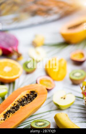 Frutta fresca tropicale estiva assortita matura e foglie tropicali su sfondo bianco. Frutta esotica asiatica. Frutta a fette in tavola. Selezionare Foto Stock