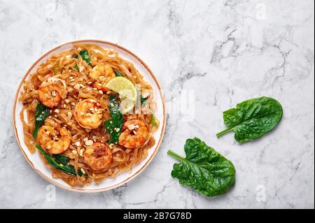 Gamberi Pad vedere EW su sfondo di marmo bianco. Il pad See EW è un piatto di cucina tailandese con tagliatelle di riso, gamberi, salsa di soia e ostriche e verdure. Thailandia foo Foto Stock