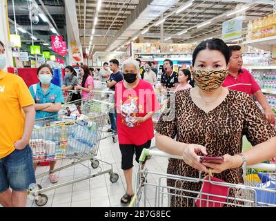 Gli acquirenti in un supermercato che indossa maschere facciali, in Thailandia. Foto Stock