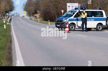 Neuhaus am Inn, Germania. 16 Marzo 2020. Gli agenti di polizia si trovano in un punto di controllo sulla strada federale B512 vicino a Neuhaus am Inn, al confine con l'Austria. La Germania ha deciso di chiudere i suoi confini almeno in parte a causa della diffusione del coronavirus. Credit: Sven Hoppe/dpa/Alamy Live News Foto Stock