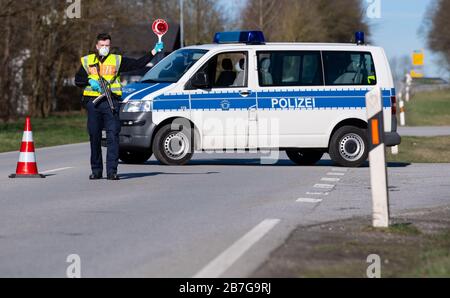 Neuhaus am Inn, Germania. 16 Marzo 2020. Gli agenti di polizia si trovano in un punto di controllo sulla strada federale B512 vicino a Neuhaus am Inn, al confine con l'Austria. La Germania ha deciso di chiudere i suoi confini almeno in parte a causa della diffusione del coronavirus. Credit: Sven Hoppe/dpa/Alamy Live News Foto Stock