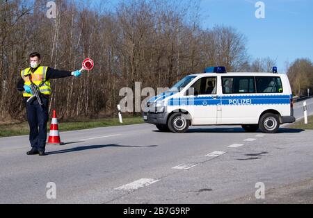 Neuhaus am Inn, Germania. 16 Marzo 2020. Un poliziotto è in piedi a un checkpoint sulla Bundesstraße 512 vicino Neuhaus am Inn in un checkpoint al confine con l'Austria. La Germania ha deciso di chiudere i suoi confini almeno in parte a causa della diffusione del coronavirus. Credit: Sven Hoppe/dpa/Alamy Live News Foto Stock