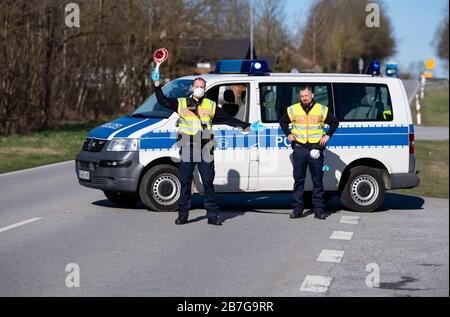 Neuhaus am Inn, Germania. 16 Marzo 2020. Gli agenti di polizia si trovano in un punto di controllo sulla strada federale B512 vicino a Neuhaus am Inn, al confine con l'Austria. La Germania ha deciso di chiudere i suoi confini almeno in parte a causa della diffusione del coronavirus. Credit: Sven Hoppe/dpa/Alamy Live News Foto Stock