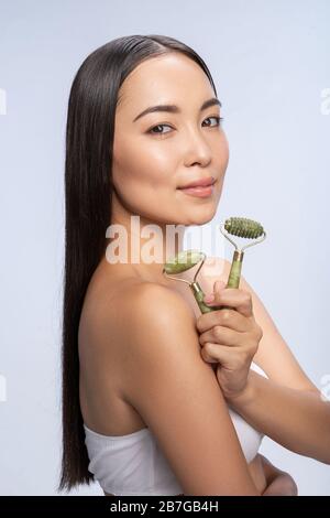 Giovane donna asiatica che posa con rullo di massaggio Foto Stock