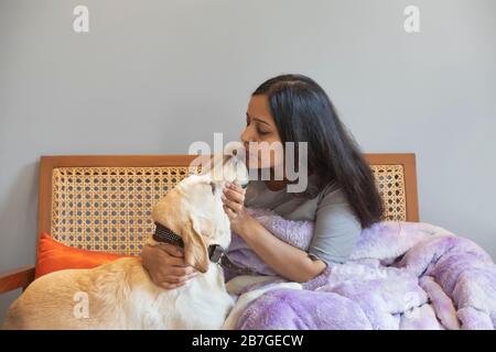 Donna che dà un bacio al suo cane. Foto Stock