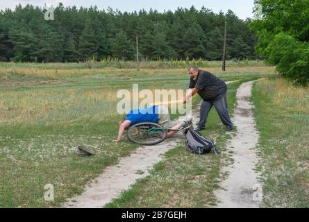 Uomo anziano che punisce il ladro che ha allontanato la sua bicicletta antica nella zona rurale Ucraina Foto Stock