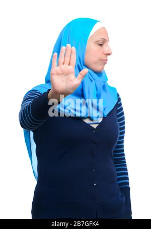 Primo piano ritratto di una giovane donna musulmana seria che mostra stop rifiuto gesto con la sua palma isolato su sfondo bianco Foto Stock