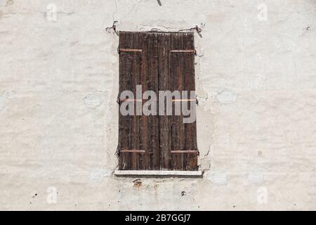 Abbandonate, rovinate vecchie finestre in legno e pareti con vecchio tetto danneggiato con vernice intemperie. Primo piano. Foto Stock