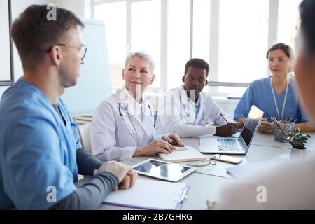 Ritratto di medico maturo capo comitato riunione al consiglio medico, spazio copia Foto Stock
