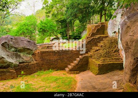 Asia Sri Lanka Sigiriya Rock Fortezza & Palace base gradini scale mattoni rossi alberi rocce turisti lontani Foto Stock