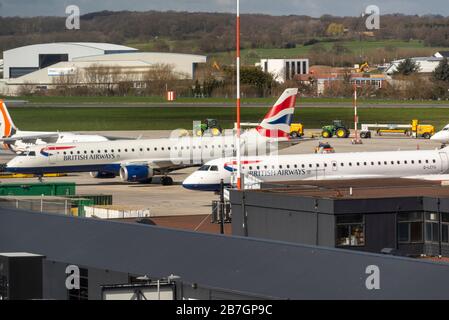 Aeroporto Southend di Londra, Essex, Regno Unito. 16 marzo 2020. Con la cancellazione di numerosi voli passeggeri europei a causa delle chiusure dei paesi Covid-19, le compagnie aeree interessate stanno radunando parte della loro flotta di aeromobili. Tre aerei della British Airways Embraer E190 sono stati parcheggiati all'aeroporto Southend di Londra, con un maggior numero di passeggeri in arrivo per lo stoccaggio Foto Stock