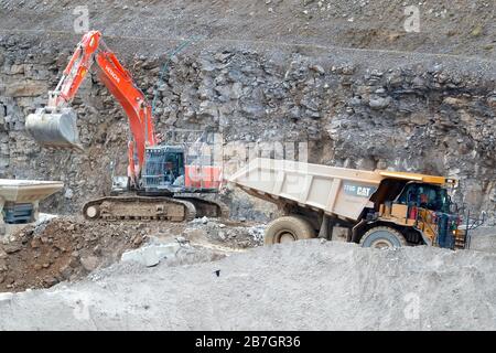 Un dumper Caterpillar 775G e un escavatore Hitachi 360 che lavorano nella cava di Coldstones, Greenhow Hill, Niddedale, nel North Yorkshire. Foto Stock