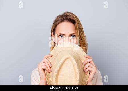 Primo piano ritratto di bella giovane donna mantenere il silenzio e nascondere il suo volto dietro cappello Foto Stock