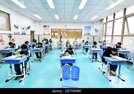 (200316) -- GUIYANG, 16 marzo 2020 (Xinhua) -- gli studenti pranzano nella loro classe nella Scuola sperimentale di mezzo n° 1 a Guiyang, nella provincia di Guizhou della Cina sudoccidentale, 16 marzo 2020. Quasi 1 milione di studenti nel loro ultimo anno di licei senior e junior nella provincia di Guizhou, nel sud-ovest della Cina, hanno frequentato le scuole dopo una lunga festa di Capodanno lunare a causa dell'epidemia di coronavirus. Autobus personalizzati per le scuole, indossare maschere, controlli di temperatura, percorsi designati per le aule per impedire la raccolta di folle -- il primo giorno di scuola indietro sembrava speciale e sicuro per gli studenti. (X Foto Stock