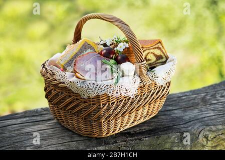 Pasqua cibo tradizionale con prosciutto, uova e pane nel cestello. Vacanze all'aperto in background Foto Stock