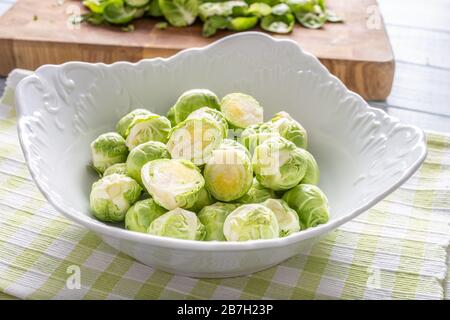 I brusseles freschi germogli in ciotola sul tavolo da cucina Foto Stock
