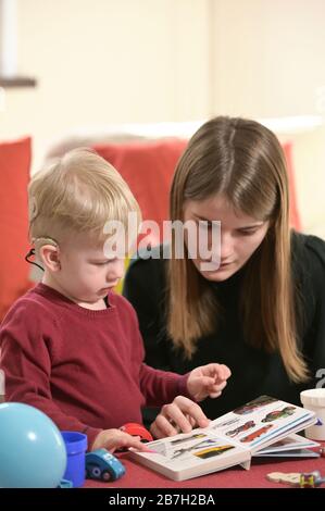 Un Ragazzo Con Apparecchi Acustici E Impianti Cochlear Giocare Foto Stock