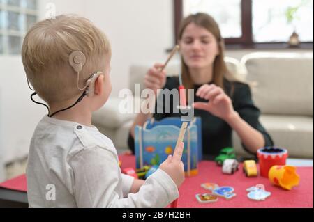 Un Ragazzo Con Apparecchi Acustici E Impianti Cochlear Giocare Foto Stock