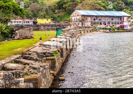 Vista sulle mura della difesa che si affacciano sulla baia di Fort Jeronimo e la dogana Real Aduana nella piazza principale di Portobelo, Panama. Foto Stock