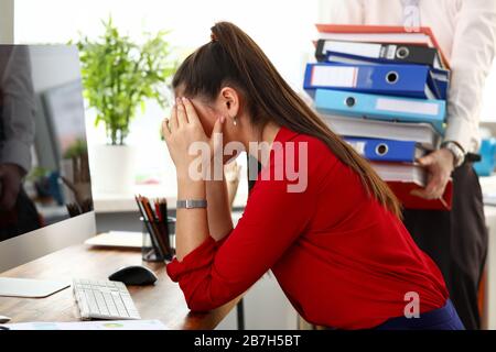 Giovane donna seduta in ufficio e sentendosi stressata ed esausta Foto Stock