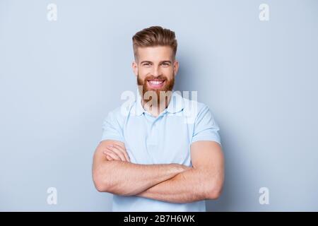 Ritratto di giovane felice bearded sorridente in polo isolato su sfondo grigio Foto Stock