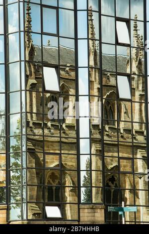 La Cattedrale Cattolica Romana di St Andrews si riflette nelle finestre di vetro di un edificio moderno, Glasgow, Scozia, Regno Unito Foto Stock