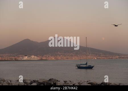 La luna che sorge dietro il Vesuvio a Napoli Foto Stock