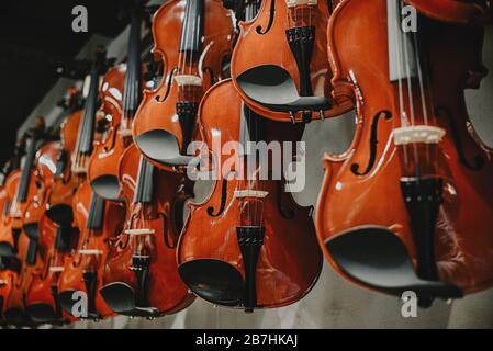 prospettiva di un violino marrone di legno nella finestra di un negozio di musica Foto Stock