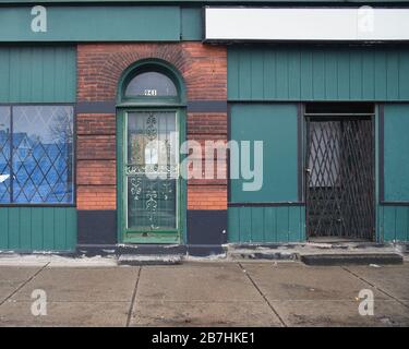 Una vecchia porta e negozi vuoti davanti finestre nel centro di Buffalo, NY per un concetto di sviluppo economico di affari Foto Stock