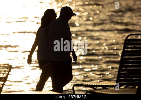 Le persone camminano lungo Lido Beach a Lido Key a Sarasota, Florida, poco prima del tramonto. Foto Stock