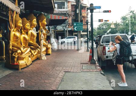 Bangkok, Thailandia - 26 gennaio 2020 : saccopelista donna non identificata utilizzando smartphone per scattare foto della statua di Buddha d'oro al buddista Foto Stock
