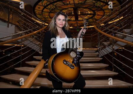 Angela Grace Brown, cantante e chitarrista, posa nell'atrio a bordo di Oceana Foto Stock