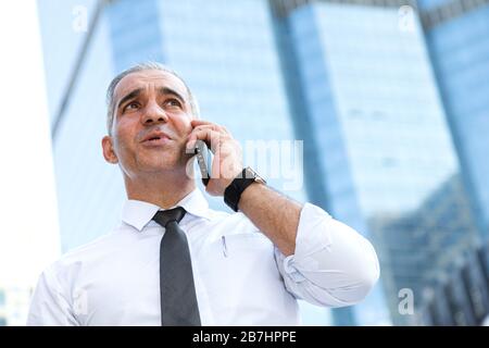 commerciante di azione, investitore, uomo d'affari che parla sul telefono mobile come preoccupato per le notizie di guerra commerciale e deluso dal mercato azionario perdente dopo checki Foto Stock