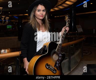 Angela Grace Brown, cantante e chitarrista, posa nell'atrio a bordo di Oceana Foto Stock