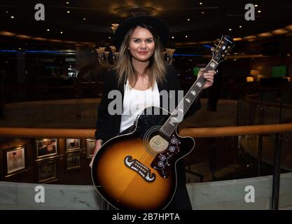 Angela Grace Brown, cantante e chitarrista, posa nell'atrio a bordo di Oceana Foto Stock