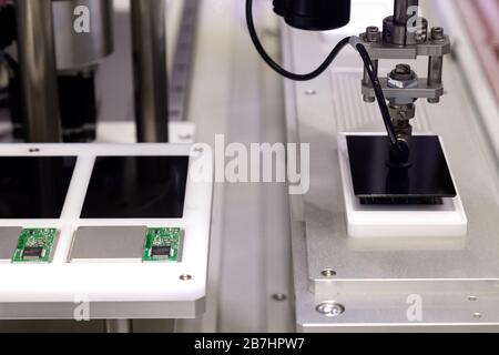 Robot automatico braccio con ventosa a depressione lavorando nella linea di produzione ed assemblaggio di schermate dello smartphone in nuove e innovative e di alta tecnologia smar Foto Stock