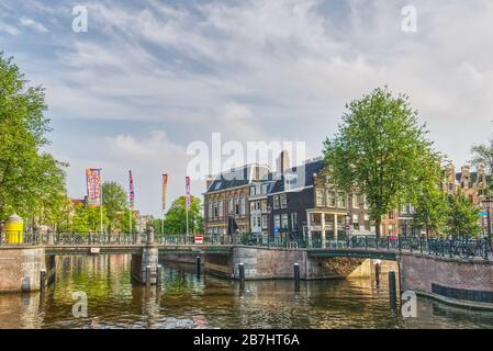 Ponti a un incrocio di canali in una giornata di sole ad Amsterdam, Paesi Bassi Foto Stock