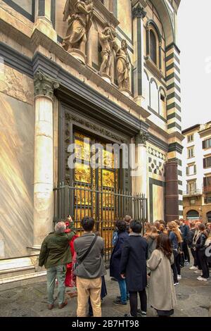 FIRENZE ITALIA MATTINA GRUPPO DI PERSONE O TURISTI FUORI DAL BATTISTERO E GOLDEN GATE OF PARADISE Foto Stock