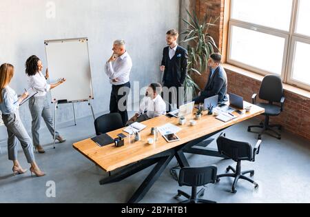 African American Businesswoman che presenta il progetto Startup ai colleghi in carica Foto Stock