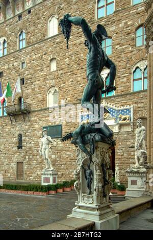 FIRENZE STATUA DI PERSEO CON LA TESTA DI MEDUSA NELLA LOGGIA DEI LANZI PALAZZO VECCHIO SULLO SFONDO Foto Stock