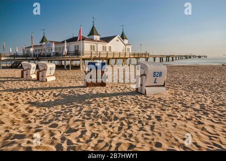 Sedie da spiaggia in vimini e Seebrücke pier in Ahlbeck sull isola di Usedom nel Meclemburgo-Pomerania Occidentale, Germania Foto Stock