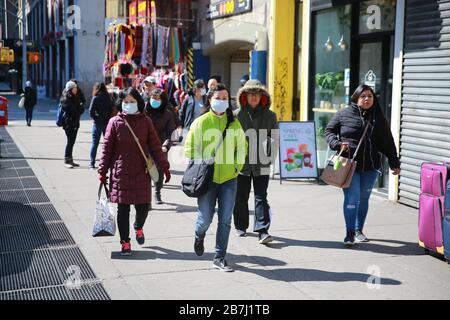 La gente cammina per le tranquille strade di Chinatown domenica 15 marzo 2020 a New York. (Foto: Gordon Donovan) Foto Stock