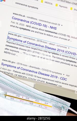 Ricerca in Internet da 'Symmpoms of Coronavirus' con la siringa medica, maschera medica facciale e termometro ad alta temperatura .immagine concettuale Foto Stock